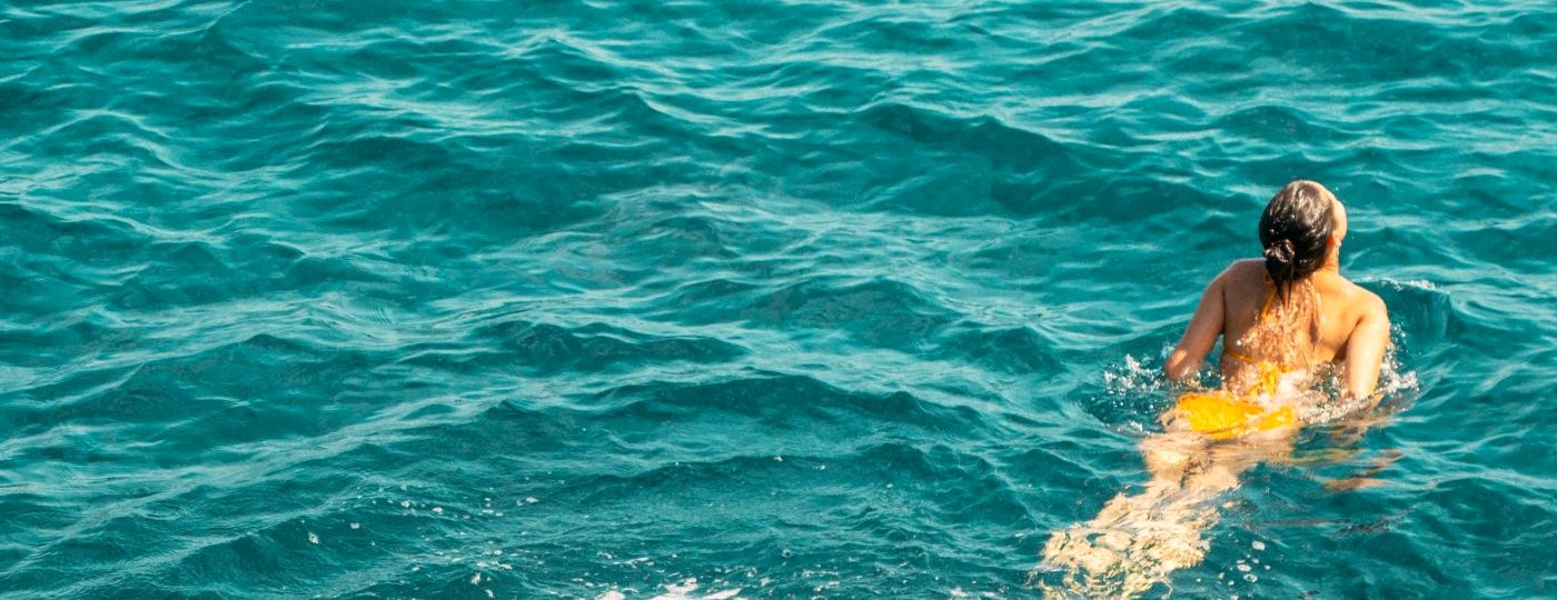 A woman swimming in clear turquoise sea